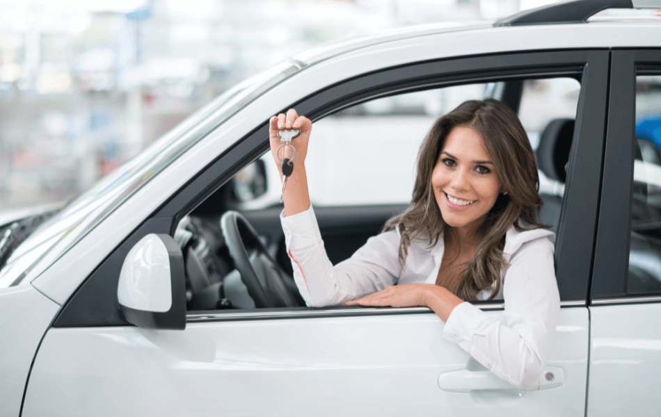 Person holding their keys up inside of a white car