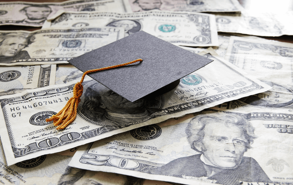 Tiny graduation cap on top of cash