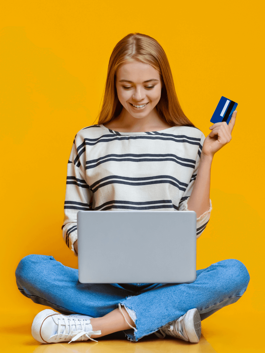 Person on laptop, holding a credit card